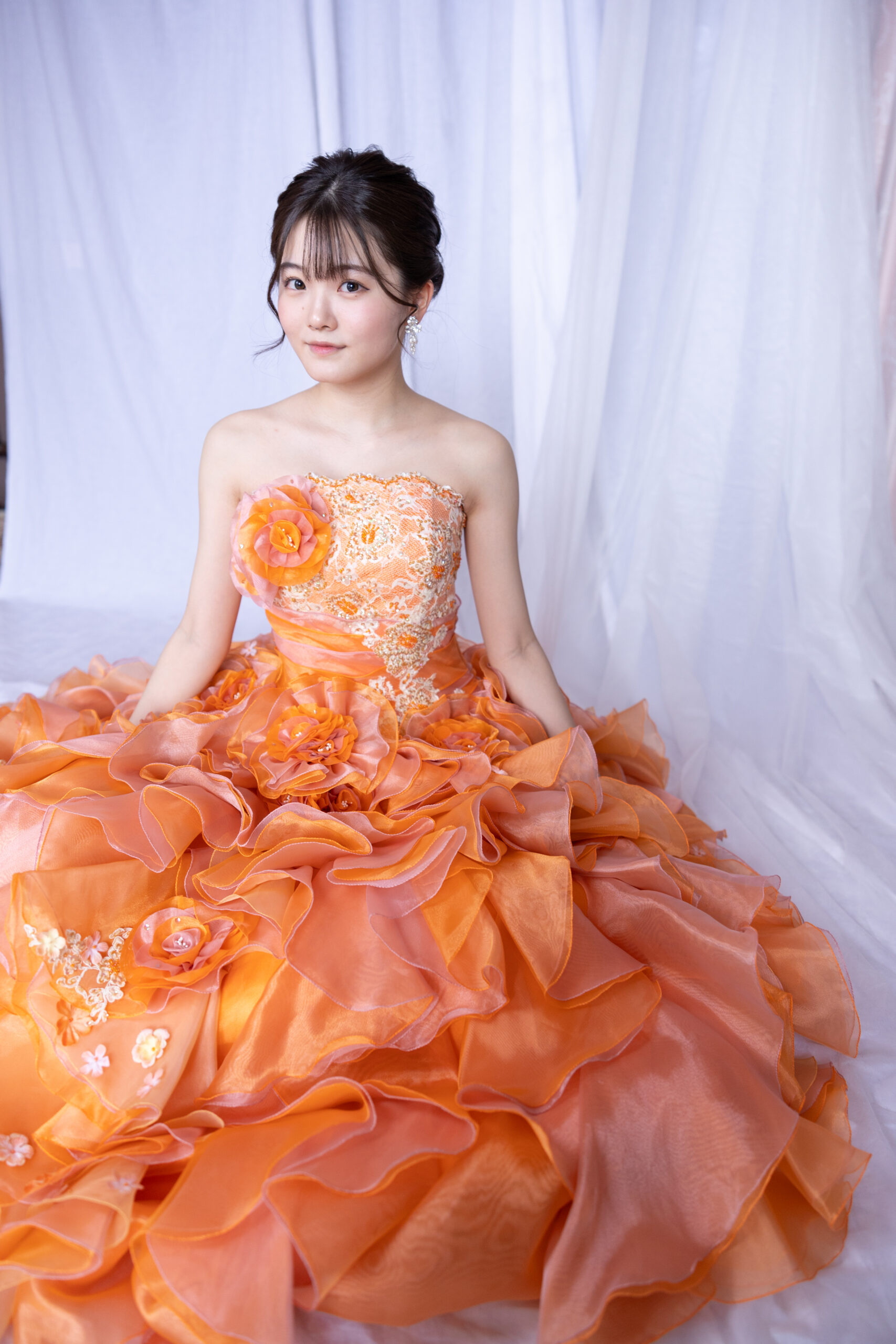 オレンジのカラードレスの女性